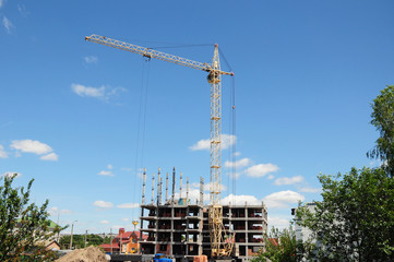 Building crane hook and building house under construction.