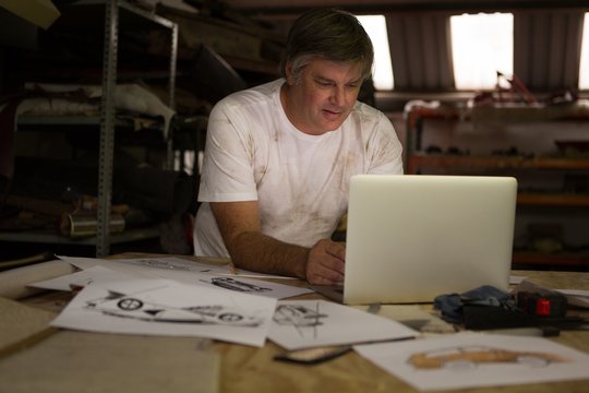 Male mechanic using laptop