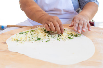 Pita bread with cottage cheese and greens. Preparing traditional bread on the street market.