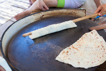 Pita bread with cottage cheese and greens. Preparing traditional bread on the street market.
