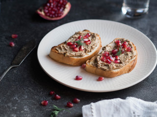 Sandwiches with chicken pate and pomegranate seeds on a white plate