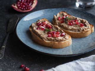Sandwiches with chicken pate and pomegranate seeds on a blue plate