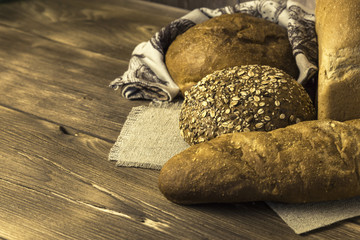 Rustic still life. Food. Assortment of fresh baked bread in the bakery on the background of a wooden table