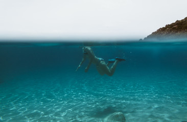 Half underwater view of a woman floating in beautiful ocean - Sardinia (Cala Regina)
