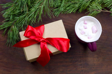 top view pine brances frame, gift box, wooden background, hot drink with marshmallows