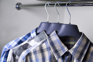 grey blue plaid shirts on hangers