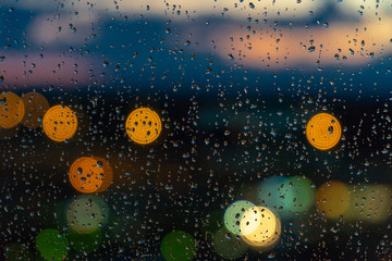 Rain On Glass Background. Street Bokeh Lights Out Of Focus.