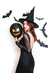 Obraz premium sexy beautiful woman in black witch halloween costumes with balloon on party over white background