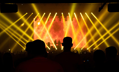 silhouette people at concert, electronic dance music, yellow light