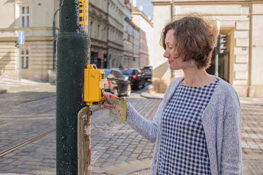 a woman is walking around the city in the spring day. Europe. Prague. A woman standing at a pedestrian crossing waiting for a traffic light
