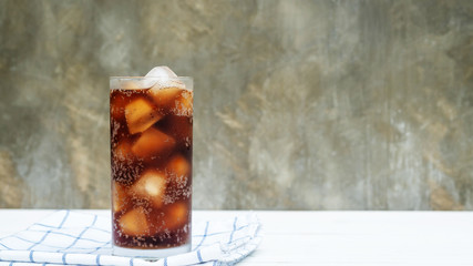 Iced aerated soft drink on a white wooden table.
