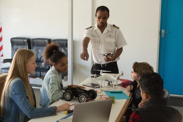 Pilot giving training about model aeroplane to students