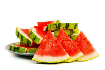 Sliced red watermelon on grey plate isolated.