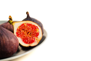 Fresh figs on grey plate. Fruit with half isolated on white.
