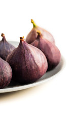 Fresh figs on grey plate isolated on white