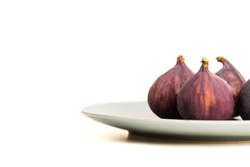 Fresh figs on grey plate isolated on white