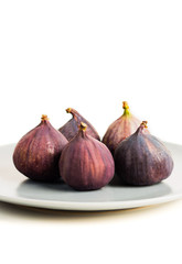 Fresh figs on grey plate isolated on white