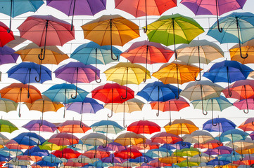 Fototapeta na wymiar Street decoration with colorful open umbrellas hanging over the alley