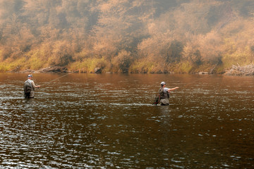 Fototapeta na wymiar fisher fishing on foggy sunrise