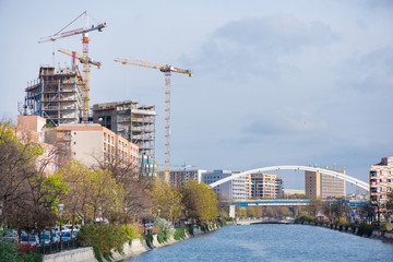 Obraz premium New residential and office block buildings being constructed next to river in city center of Bucharest. 