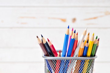 Colored pencils in pencil case  on wooden background.

