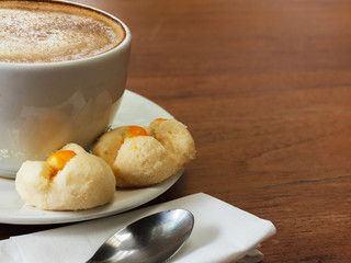 Coffee cup and macarons on wooden table