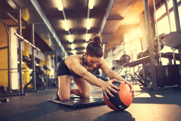 Girl in gym train with ball