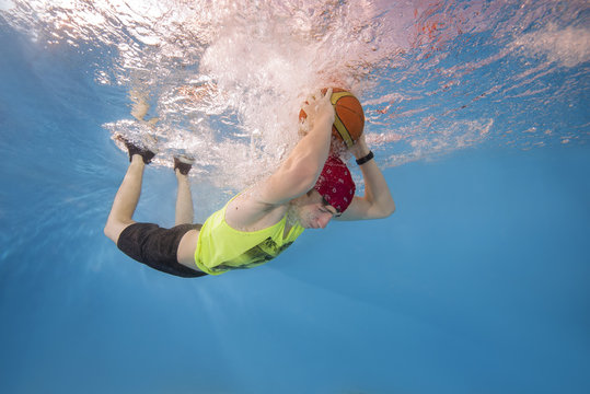 Teenager playing basketball underwater - Powered by Adobe