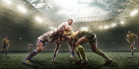 Rugby players fight for the ball on professional rugby stadium