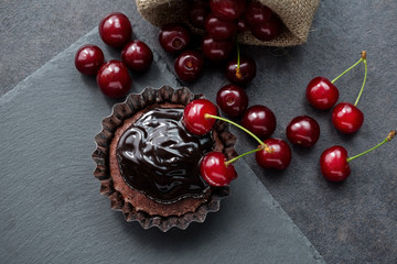 Muffin, chocolate, cherry, rustic style background.