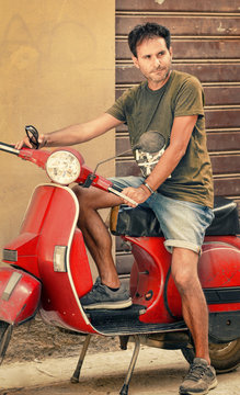 Man driving vintage scooter