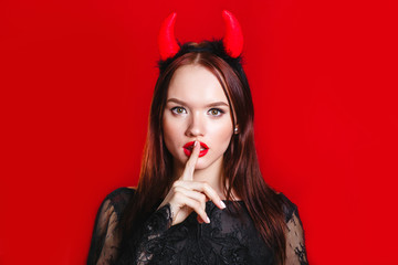 Sexy halloween woman devil on red background .