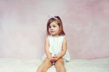 Preciosa niña pequeña posando en un estudio