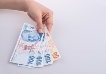Hands holding Turksh Lira banknotes by the side of American dollar banknotes