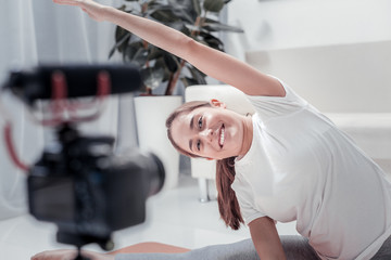 Wellbeing. Nice smiling woman doing sports taking care of her health at home