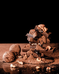 Truffles and chocolate with nuts. Black background.