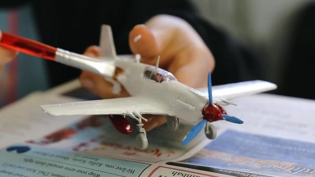 Close up shot of a model plane being painted.
