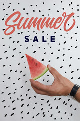 cropped shot of man holding watermelon piece in hands on white surface with summer sale lettering