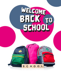 three colored schoolbags and wooden cubes with word school isolated on white, with "welcome back to school" lettering