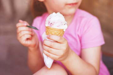 girl in pink dress eating ice cream