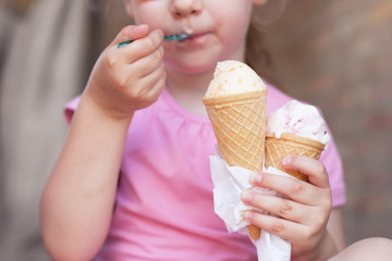 girl in pink dress eating ice cream