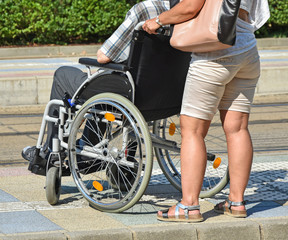 Old man in a wheelchair and a woman