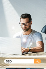 handsome developer working with laptop with SEO search bar
