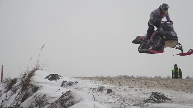Russia, Championship on snowmobiles January 27, 2018: Winter racing on snowmobiles. Snowmobile on the route in a jump. Action from snowmobile races.