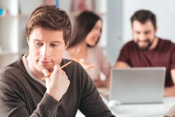 Thoughtful look. Nice smart man holding his chin while thinking about a solution to the problem