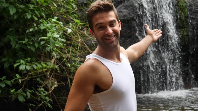 Smiling hunk by waterfall
