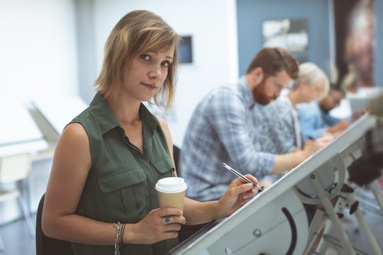 Female executive working on drafting table in office