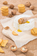 Fototapeta na wymiar Camembert cheese with crackers walnuts and honey.