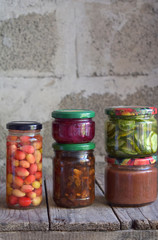 Variety of preserved food in glass jars - pickles, jam, marmalade, sauces, ketchup. Preserving vegetables and fruits. Fermented food. Autumn canning. Conservation of harvest.