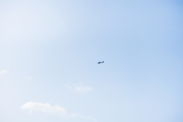 Military helicopters flying in the sky over a city and crowded event, taking photos, filming from above on clear blue sky background. An Isolated helicopter. Team of rescuers searching for lost people